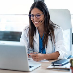 female-doctor-talking-with-colleagues-through-a-video-call-with-a-laptop-in-the-consultation--e1736290714490.jpg