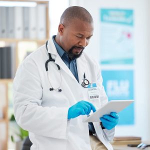 focused-doctor-using-a-digital-tablet-in-his-clinic-office-african-american-specialist-using-an-on.jpg